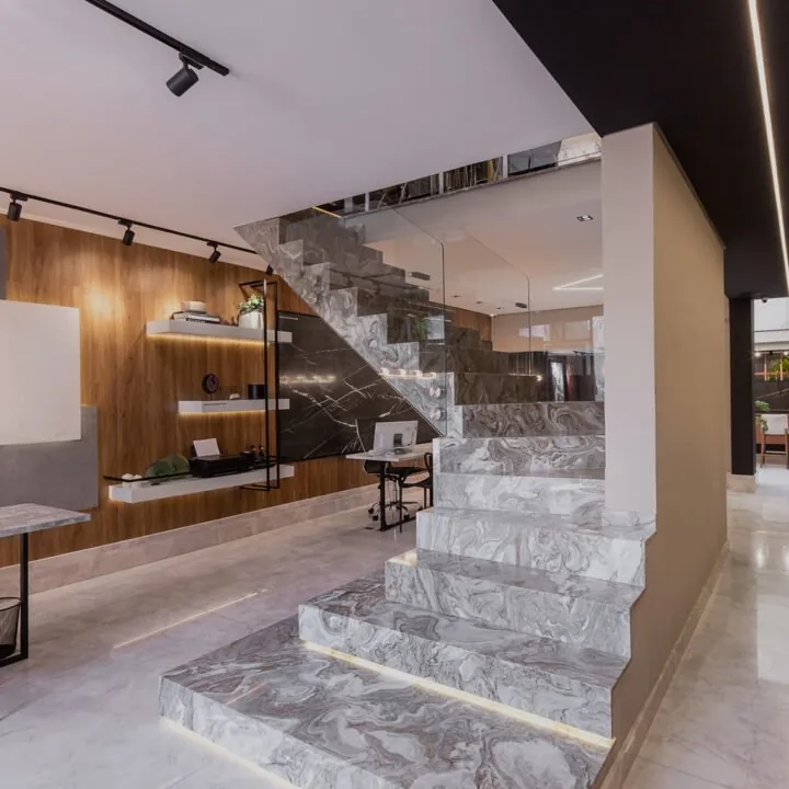 Escada revestida em mármore cinza com iluminação embutida