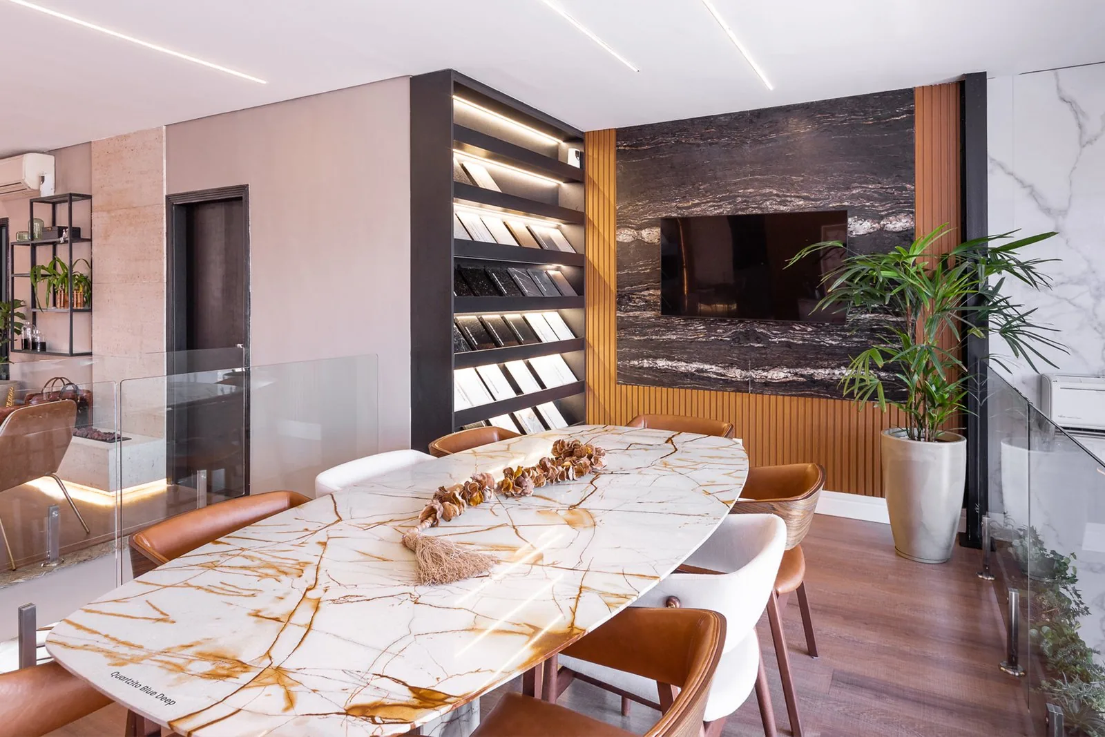 Sala de jantar com mesa de mármore branco e detalhes em madeira
